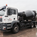 Side view of concrete truck mixer in action