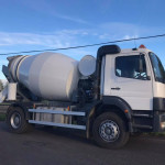 Truck mixer parked at depot, angled side view